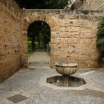 EIn kleiner Brunnen und eine antike Mauer im königlichen Garten von Palma