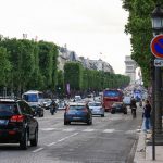 Blick über die Ein Straßenkünstler an der Champs-Élysées mit dem Arc de Triumph im Hintergrund